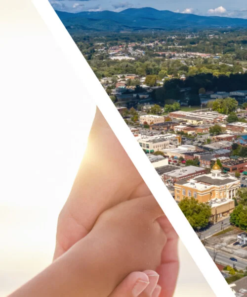 Hands holding with a cityscape and mountains in the background.