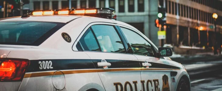 Side view of a marked police cruiser in an urban area.